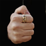 Hand wearing a gold ring on a black background
