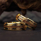 Gold rings with black accents on a dark background