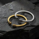 Three braided bracelets in gold, silver, and black 