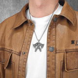 Person wearing a brown jacket with a white shirt and a necklace with a pendant of double Viking Axes.