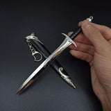 Hand holding a decorative dagger with intricate designs on a dark background