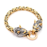 Gold and silver bracelet with wolf head designs on a white background