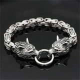 Silver bracelet with wolf head designs on a black background
