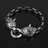 Silver bracelet with wolf head designs on a black background