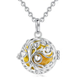 Silver necklace with a round pendant featuring a yellow center on a white background