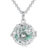 Silver necklace with a round pendant featuring a tree of life design on a white background