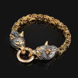 Gold and silver bracelet with wolf head designs on a black background