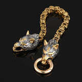 Gold and silver wolf head keychain on a black background