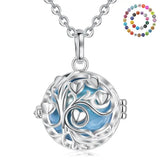 Silver necklace with a round pendant featuring a tree of life design on a white background