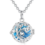 Silver necklace with a round pendant featuring blue interior and floral design on a white background