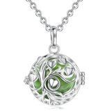 Silver necklace with a green tree of life pendant on a white background