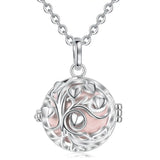 Silver necklace with a round pendant featuring heart designs on a white background