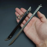 Decorative sword and sheath held in a hand against a dark background