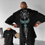 Person wearing a black t-shirt with intricate designs on the back, including a compass and eagle emblem.