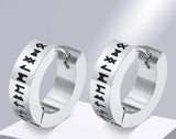 Pair of silver hoop earrings with engraved Rune symbols on a gray background