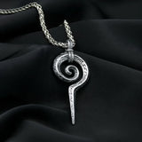 Silver spiral pendant necklace on a black fabric background