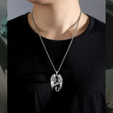 Person wearing a necklace with a heart-shaped pendant on a black top.