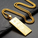 Gold bar pendant necklace on a dark surface