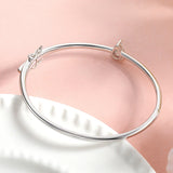 Silver bracelet on a pink and white fabric background