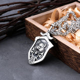 Silver pendant with lion design on a wooden box