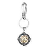 Silver keychain with a gold tree of life design on a white background