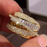 Close-up of a hand holding three diamond rings with a blurred background