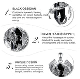 Black obsidian pendant with silver plating on a white background