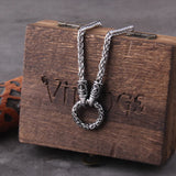 Silver necklace with intricate Rune design on a wooden box with 'Vikings' branding.