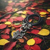 Black braided leather necklace with silver wolf head pendant on a white background