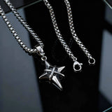 Silver chain necklace with a star-shaped pendant on a dark background