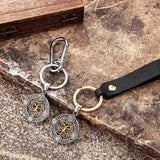 Two keychains with decorative pendants on a textured surface