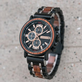  wooden watch with black strap and detailed face on a blurred background