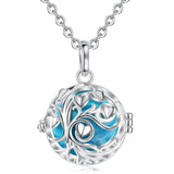 Silver necklace with a round pendant featuring blue interior and heart designs on a white background