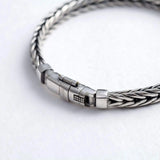 Close-up of a silver braided bracelet on a white background