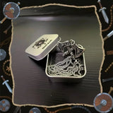 Viking-style axe pendant in a tin box with decorative elements on a dark background