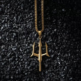 Gold necklace with a trident pendant on a black textured background