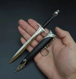 Hand holding a decorative dagger with intricate designs on a dark background