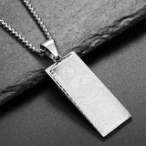 Silver pendant shaped like a dollar bill on a dark stone surface