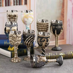 Set of wine goblets on books with skull, skeleton hand and dragon