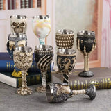 Set of wine goblets on books with skull, skeleton hand and dragon