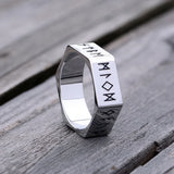 Silver ring with engraved symbols on a wooden surface