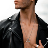 Man wearing a black leather jacket with a triangle necklace.