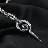 Silver spiral pendant necklace on a black fabric background