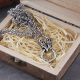 Silver chain necklace with decorative elements in a wooden box