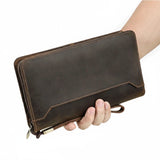 Brown leather wallet held by a hand 