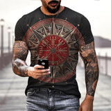 Man wearing a black t-shirt with a red and gold compass design, holding a phone.