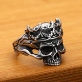 Silver skull ring with detailed design on a wooden surface
