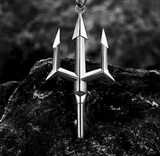 Silver trident pendant on a dark rock background