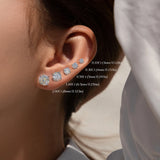 Close-up of an ear wearing diamond earrings with size labels.