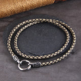 Braided leather necklace with silver clasp on a dark surface